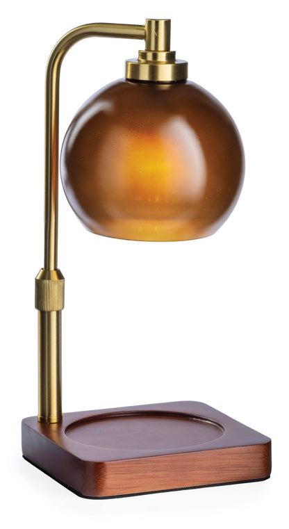 A vintage-style desk lamp with a round amber glass shade, a curved brass metal arm, and a square dark brown wooden base, shown on a plain white background.