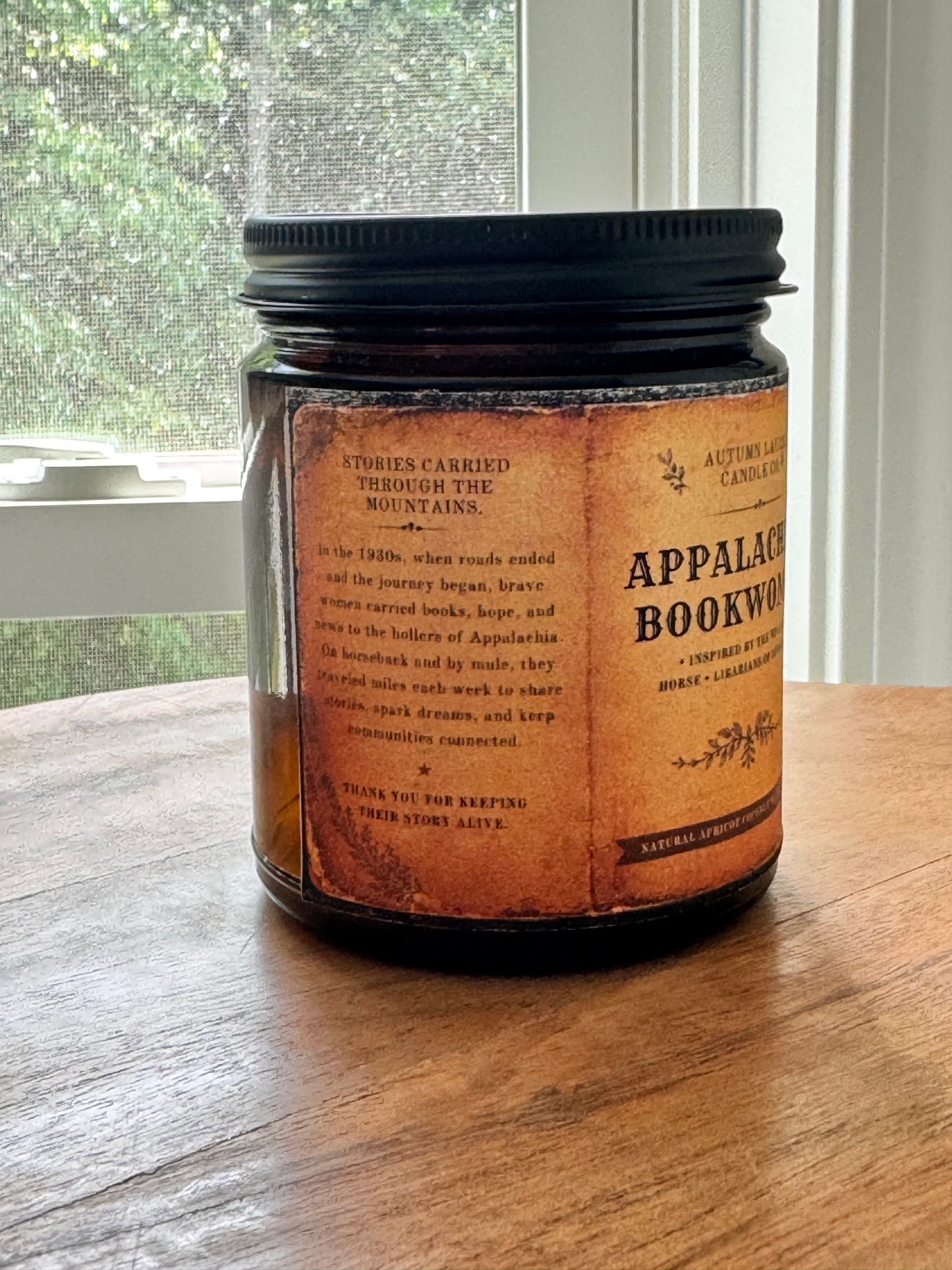 An aged-paper storytelling panel inspired by Appalachian oral traditions and the Pack Horse Librarians of Appalachia. The candle label includes a hidden scent story printed in faded archival typography, designed to resemble a weathered historical book page.