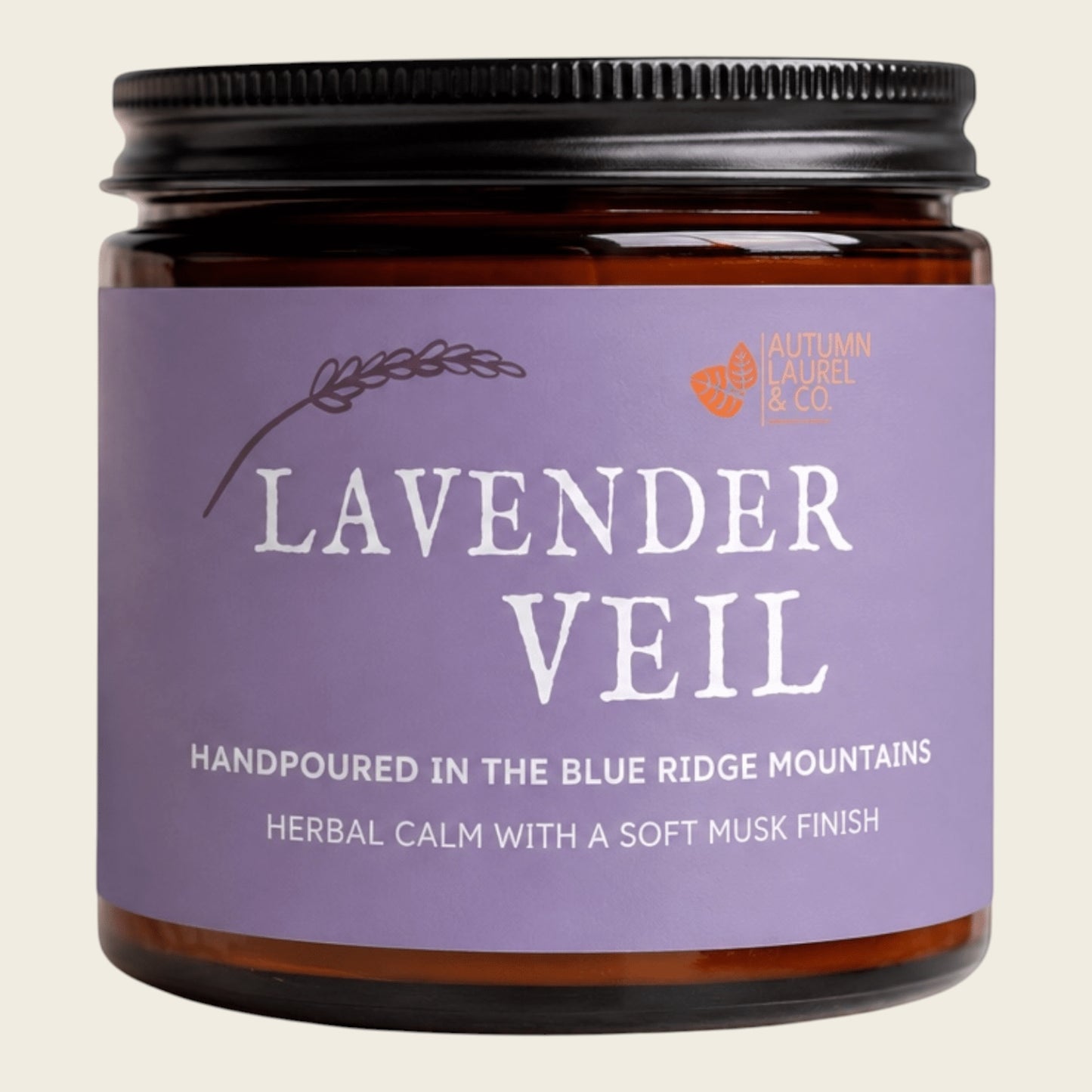A jar of lavender scented candle with a black metal lid and a lavender purple label reading 'LAVENDER VEIL' by Autumn Laurel & Co, on a light beige background.
