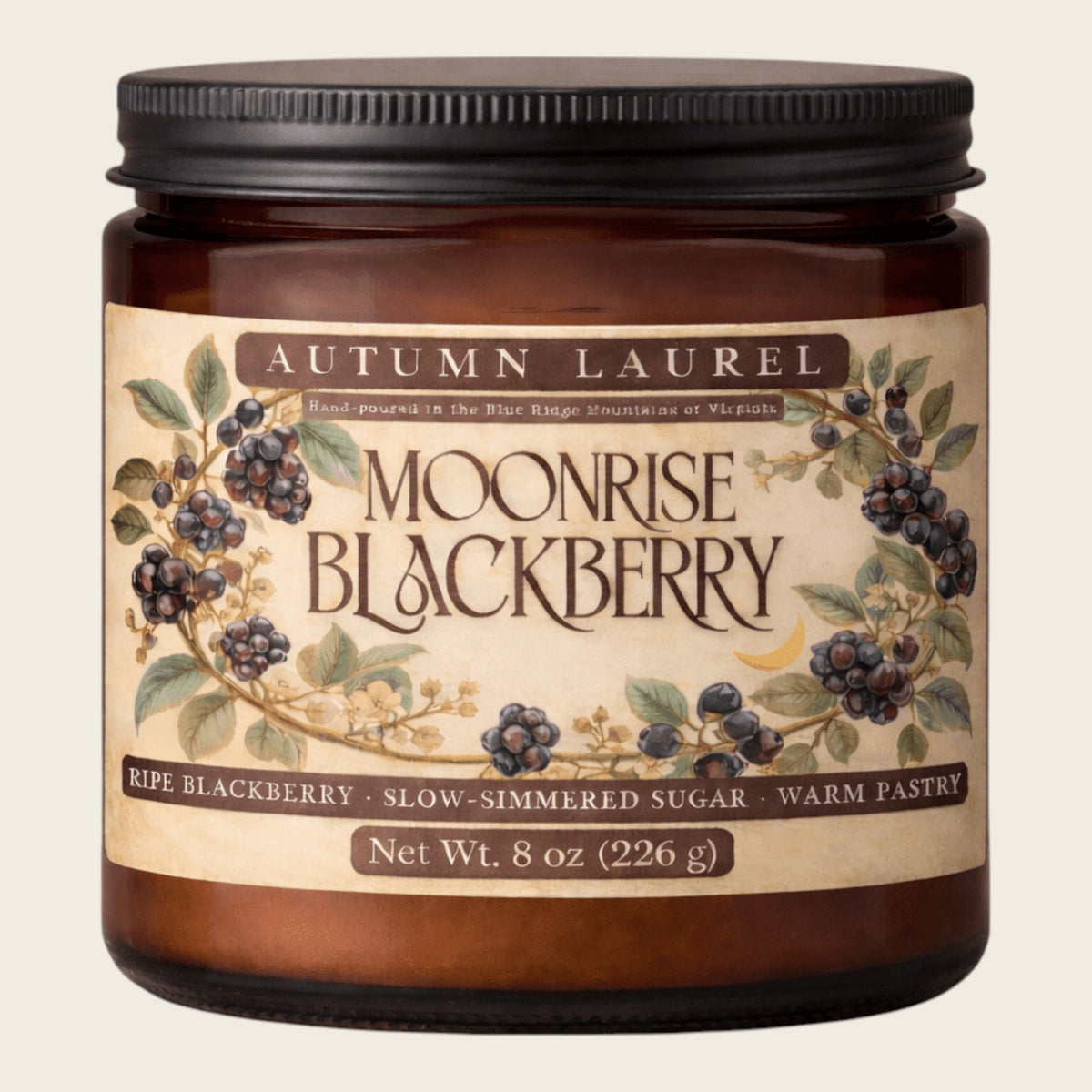 An 8 oz amber glass jar candle with a black metal lid and a vintage-style cream label reading 'Autumn Laurel Moonrise Blackberry'. The label features illustrations of blackberries and leaves on a light beige background.